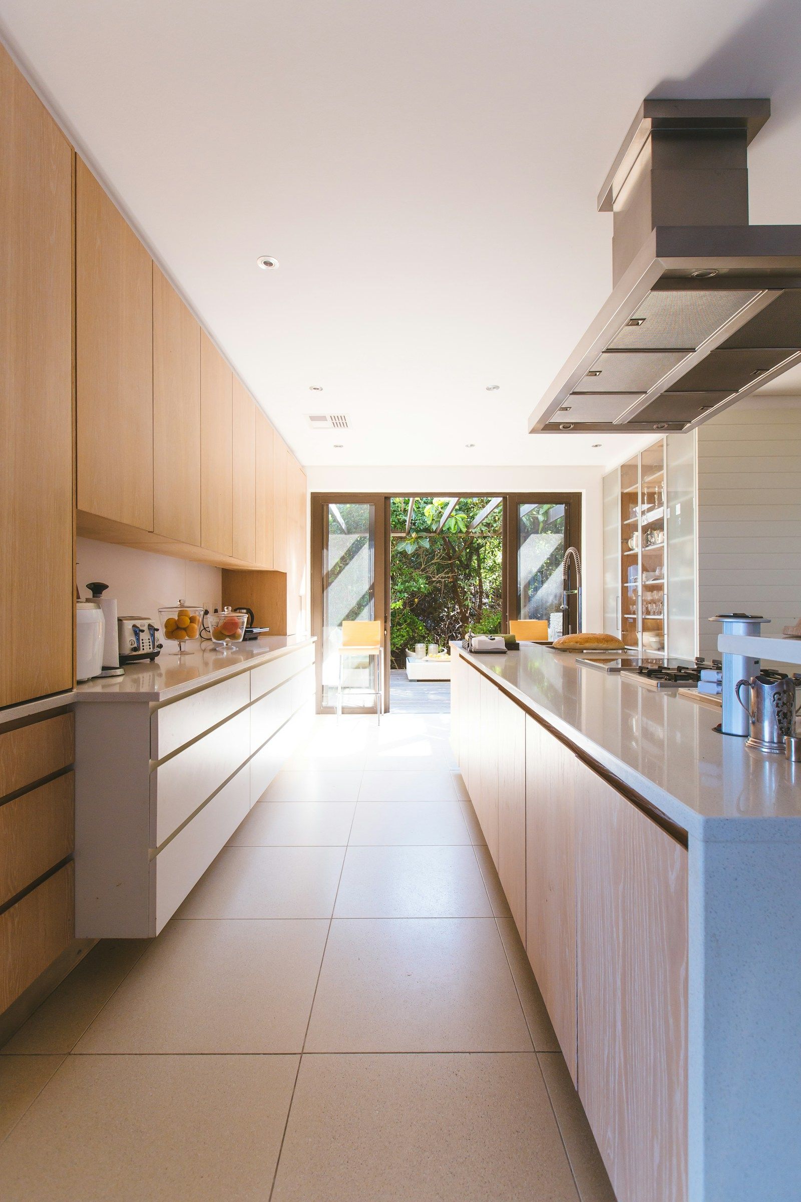 Bright, tidy kitchen with clear countertops and sunlight from the garden doors